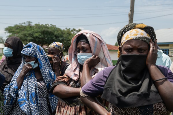 Relatives look on as people who died of Ebola are taken from a health center in Rwampara, Congo, Wednesday, May 20, 2026. (AP Photo/Moses Sawasawa)