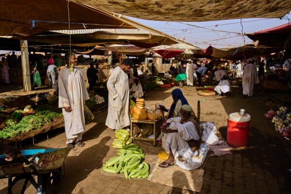 Customers buy vegetables at a market in Omdurman, on the outskirts of Khartoum, Sudan, Sunday, April 26, 2026. (AP Photo/Bernat Armangue)